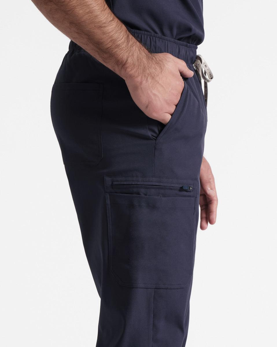 Close up view of man wearing navy cargo scrub pants with his hand in a pocket.