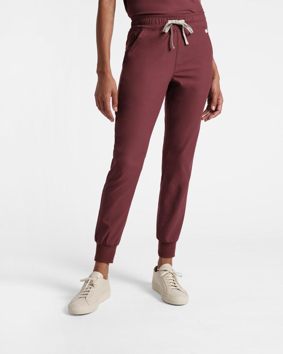 Woman in deep red jogger scrub pants with soft ribbed ankle cuffs.