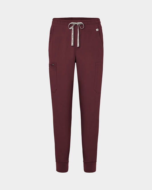 Dark heme red jogger-style scrub pants with a white drawstring, cargo pockets, and a small white logo on the upper right hip, shown against a light gray background.