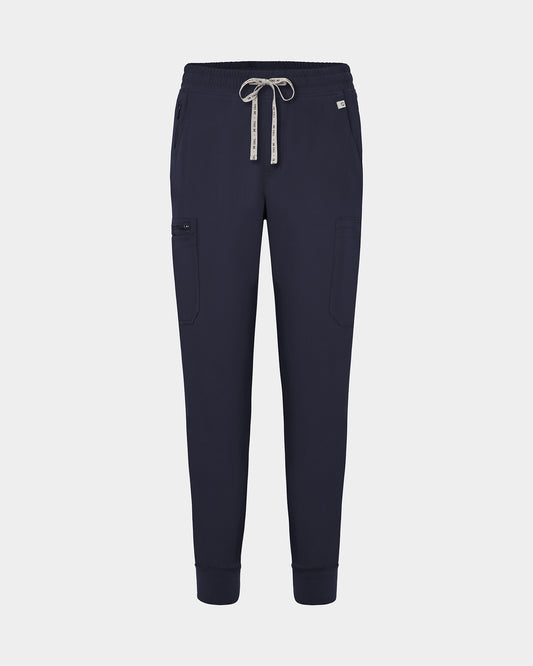 Navy jogger-style scrub pants with a white drawstring, cargo pockets, and a small white logo on the upper right hip, shown against a light gray background.