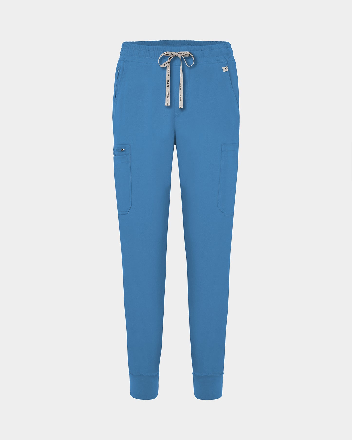 Bright blue jogger-style scrub pants with a white drawstring, cargo pockets, and a small white logo on the upper right hip, shown against a light gray background.