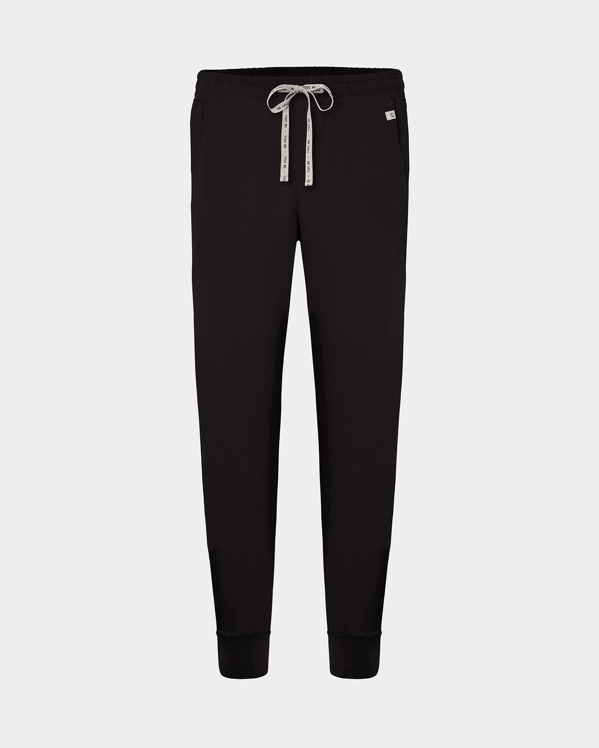 Black jogger scrub pants with a white patterned drawstring and a small white brand tag on the right hip, shown against a light gray background.
