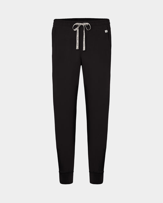 Black jogger scrub pants with a white patterned drawstring and a small white brand tag on the right hip, shown against a light gray background.