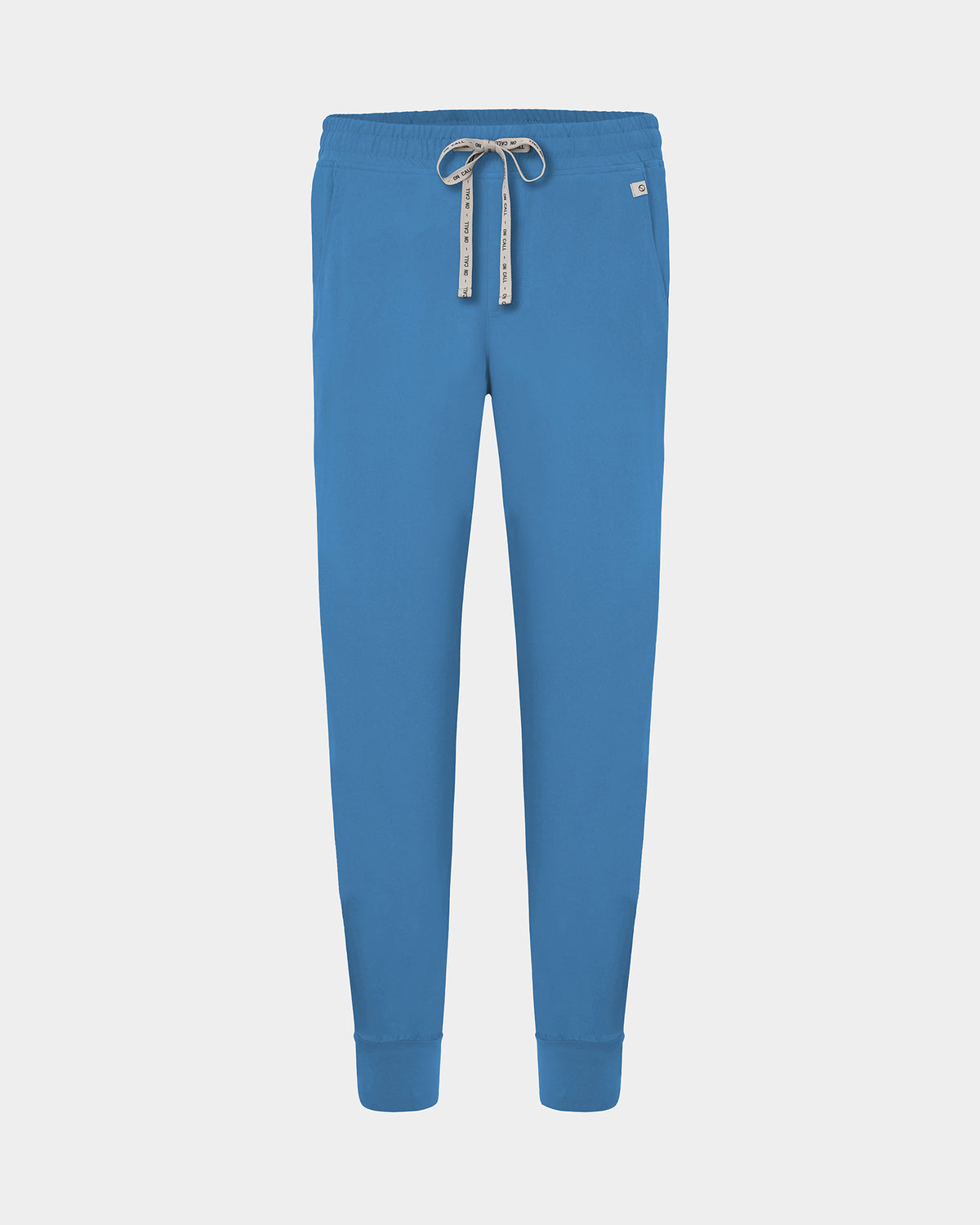 Bright blue jogger-style scrub pants with an elastic waistband, logo drawstring, and ankle cuffs, shown on a light gray background.