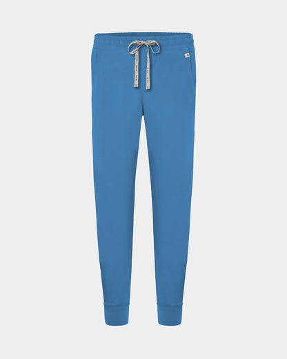 Bright blue jogger-style scrub pants with an elastic waistband, logo drawstring, and ankle cuffs, shown on a light gray background.
