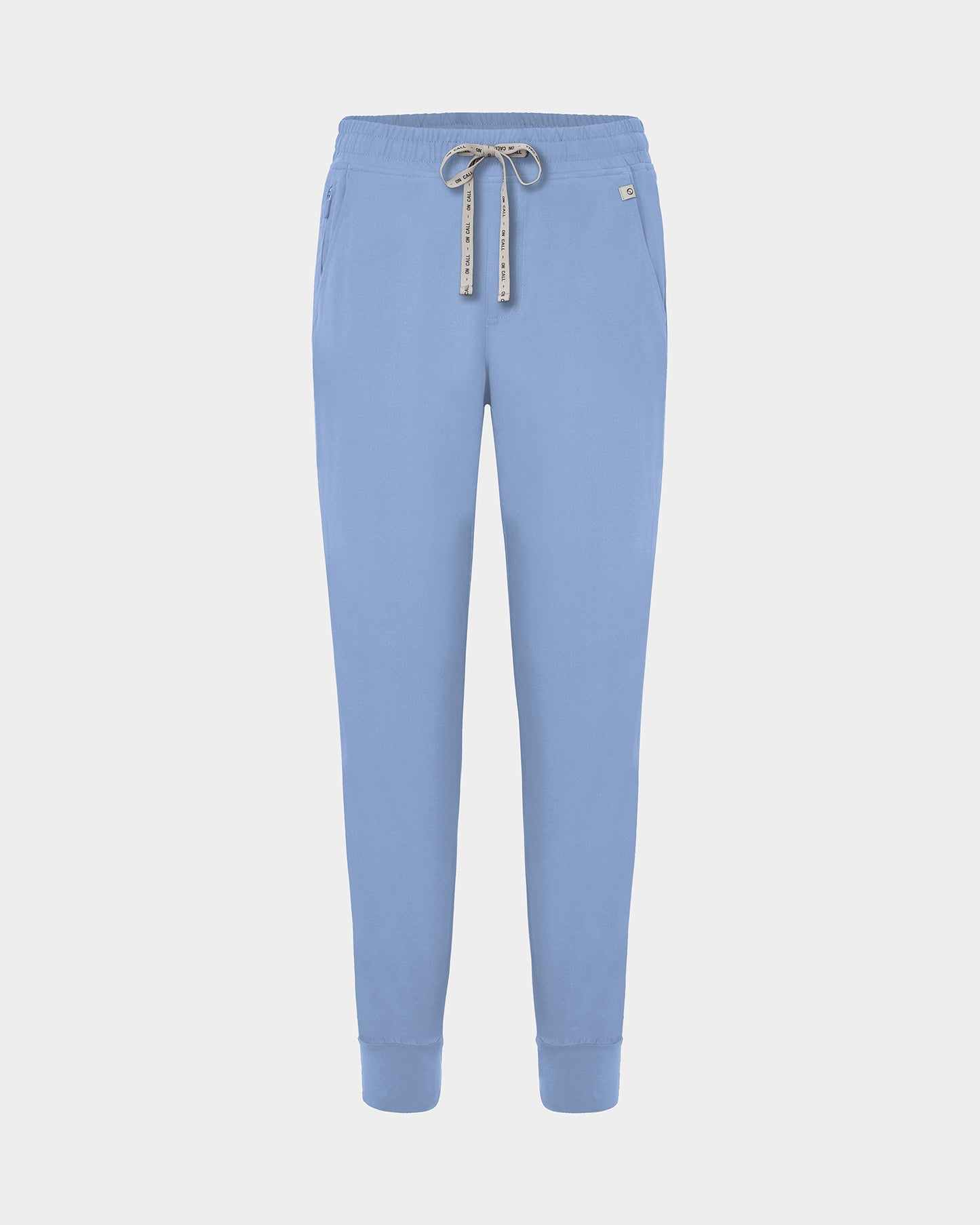 Light blue jogger scrub pants with a logo drawstring, ankle cuffs, and a small white logo on the left hip, shown against a light gray background.