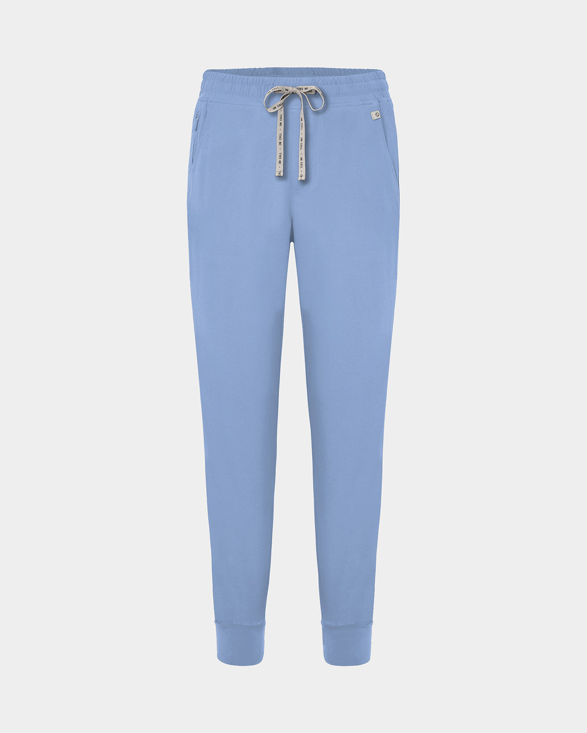 Light blue jogger scrub pants with a logo drawstring, ankle cuffs, and a small white logo on the left hip, shown against a light gray background.