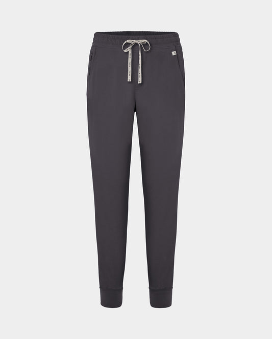 Dark grey jogger scrub pants with a logo drawstring, ankle cuffs, and a small white logo on the left hip, shown against a light gray background.