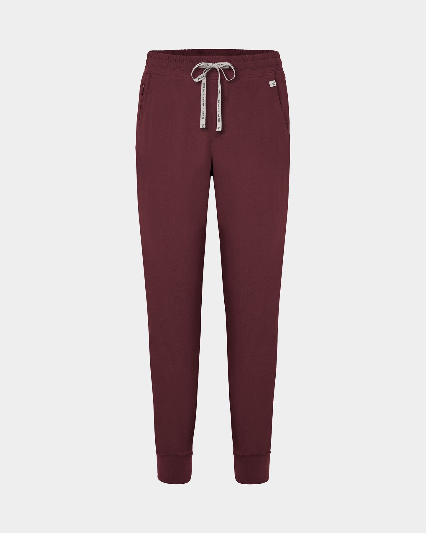 Dark heme red jogger scrub pants with a logo drawstring, ankle cuffs, and a small white logo on the left hip, shown against a light gray background.