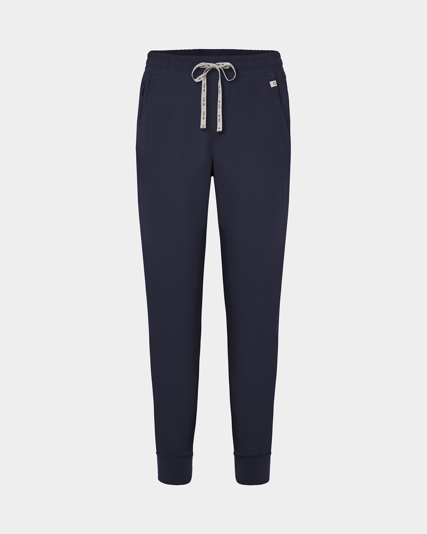 Navy jogger scrub pants with a logo drawstring, ankle cuffs, and a small white logo on the left hip, shown against a light gray background.