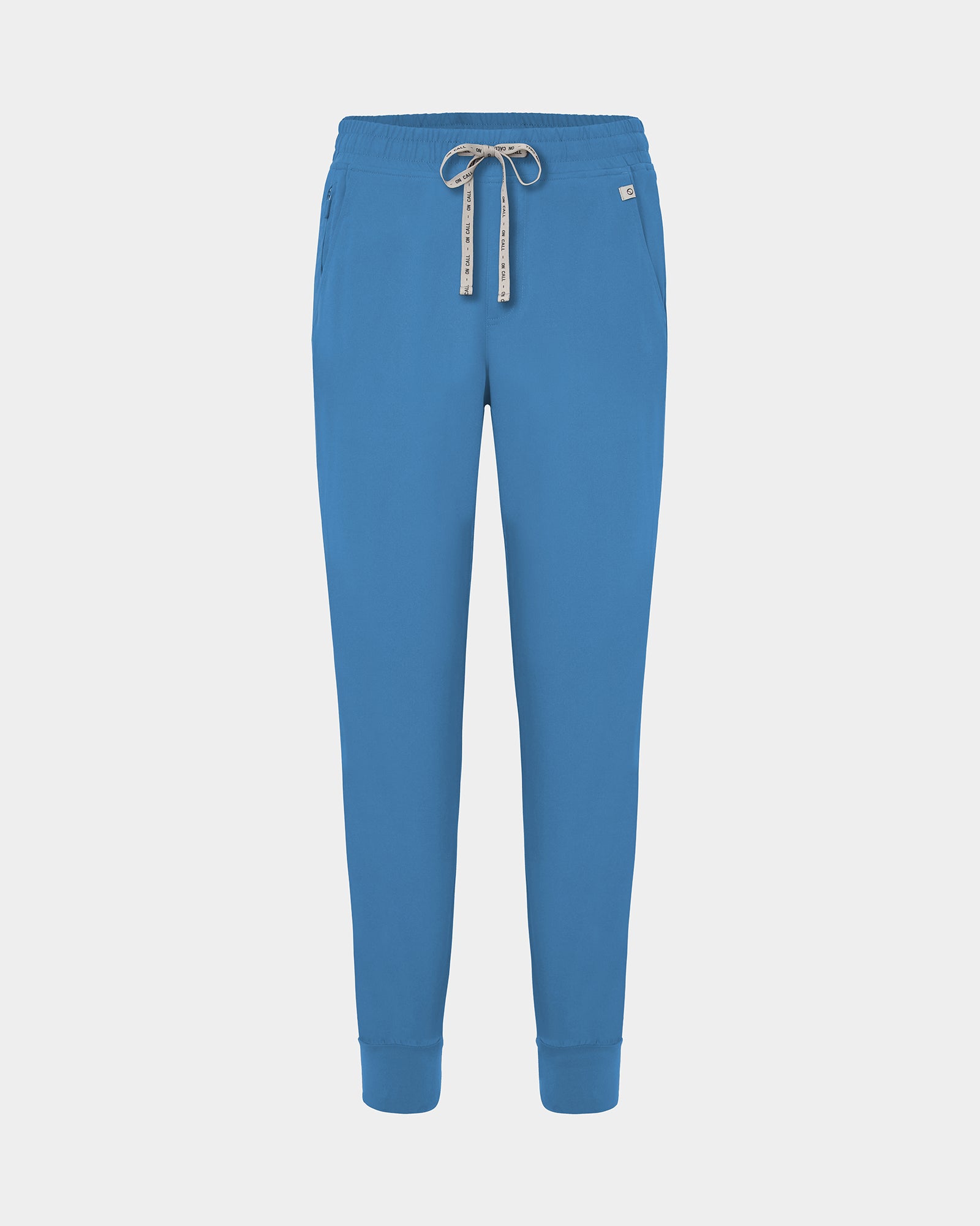 Bright blue jogger scrub pants with a logo drawstring, ankle cuffs, and a small white logo on the left hip, shown against a light gray background.