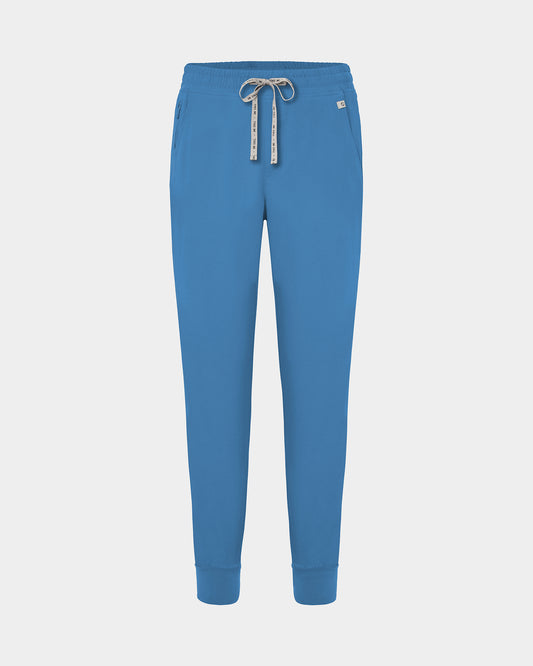 Bright blue jogger scrub pants with a logo drawstring, ankle cuffs, and a small white logo on the left hip, shown against a light gray background.