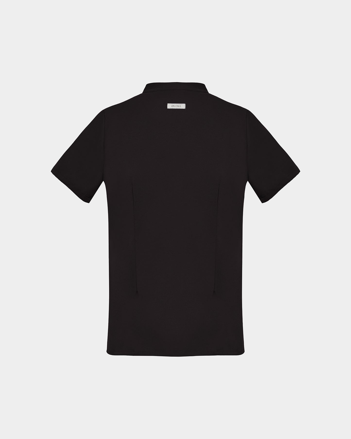 A black short-sleeve scrub shirt with a logo label under the collar, shown from the back on a light gray background.