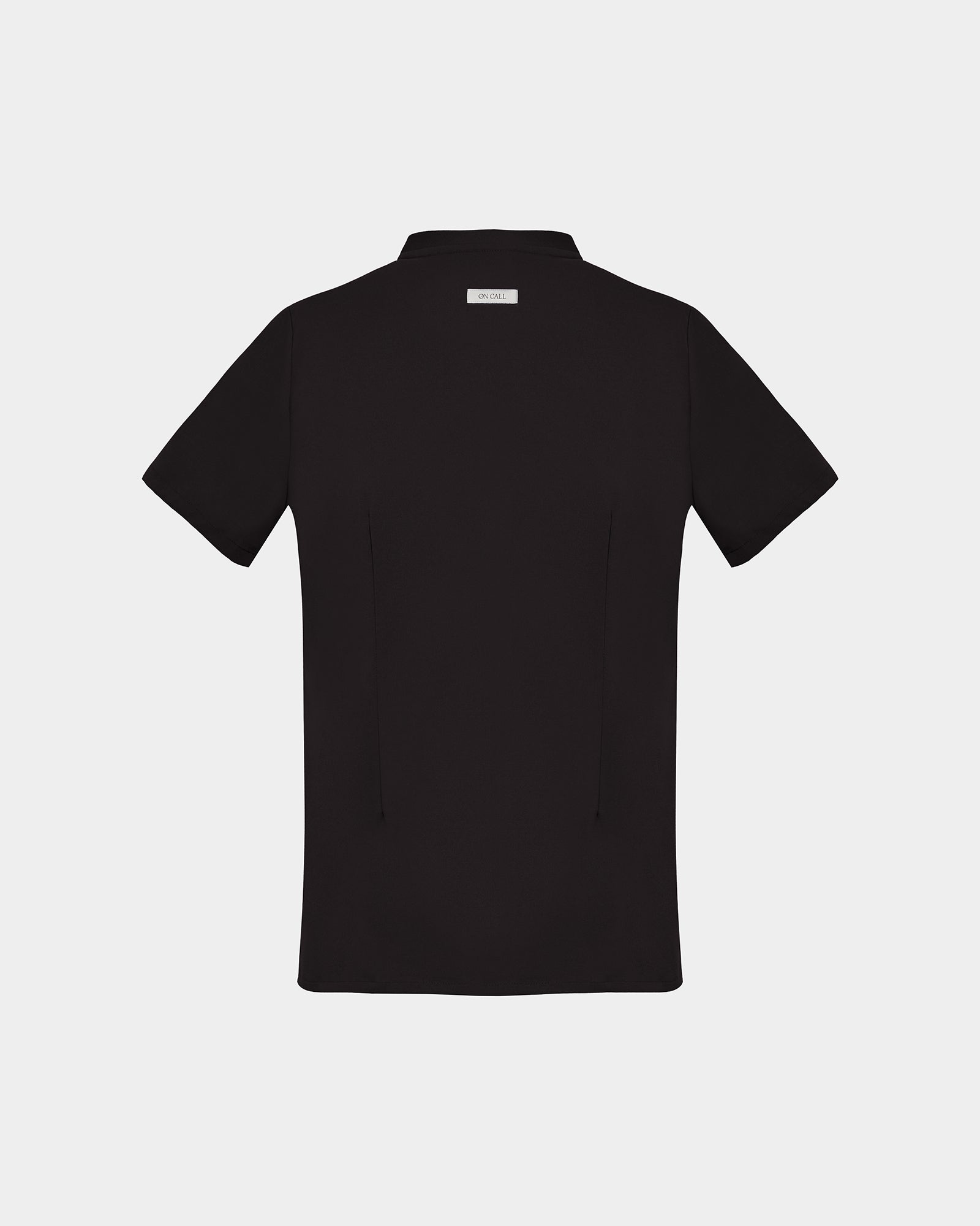 A black short-sleeve scrub shirt with a logo label under the collar, shown from the back on a light gray background.