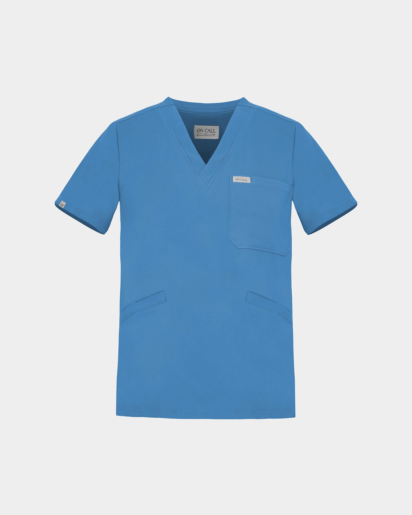 A bright blue V-neck scrub top with short sleeves, a chest pocket, and two lower front pockets, shown flat against a light gray background.